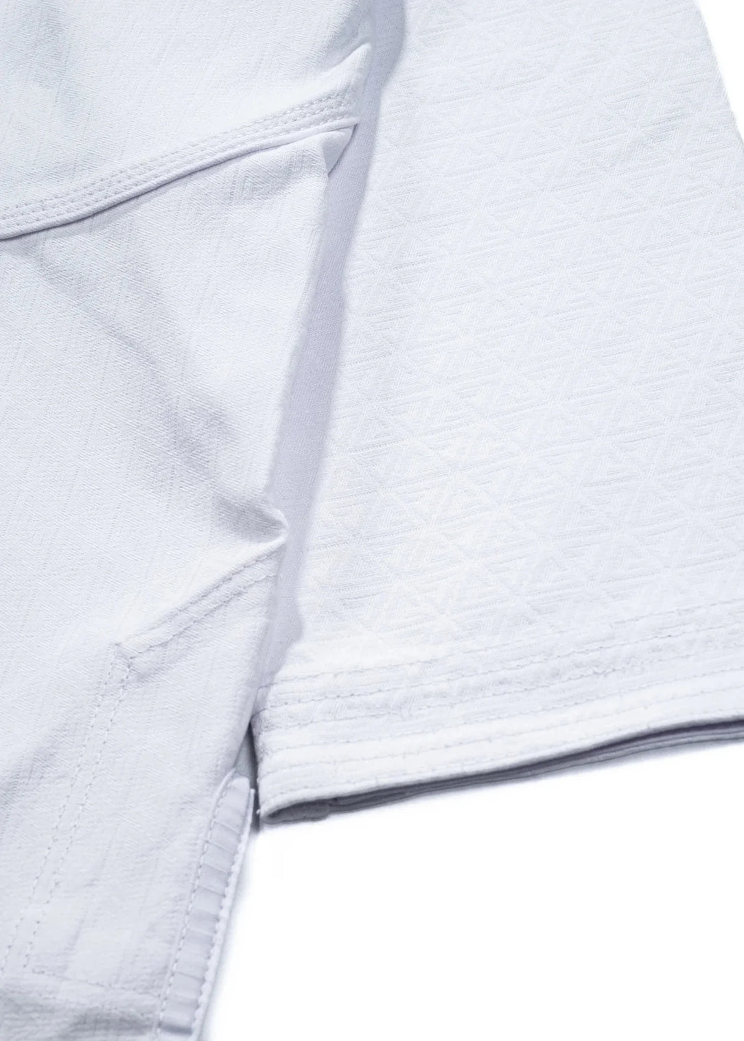 Close-up of the 40 Year Anniversary Women's Kimono custom jacquard weave with tonal Legacy G embroidered throughout the white fabric